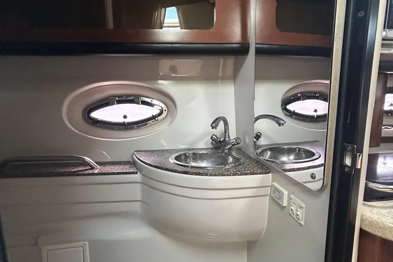 Slide: The Image of 2015 Crownline 350 SY yacht bathroom with sink, mirror, and porthole window. - 19