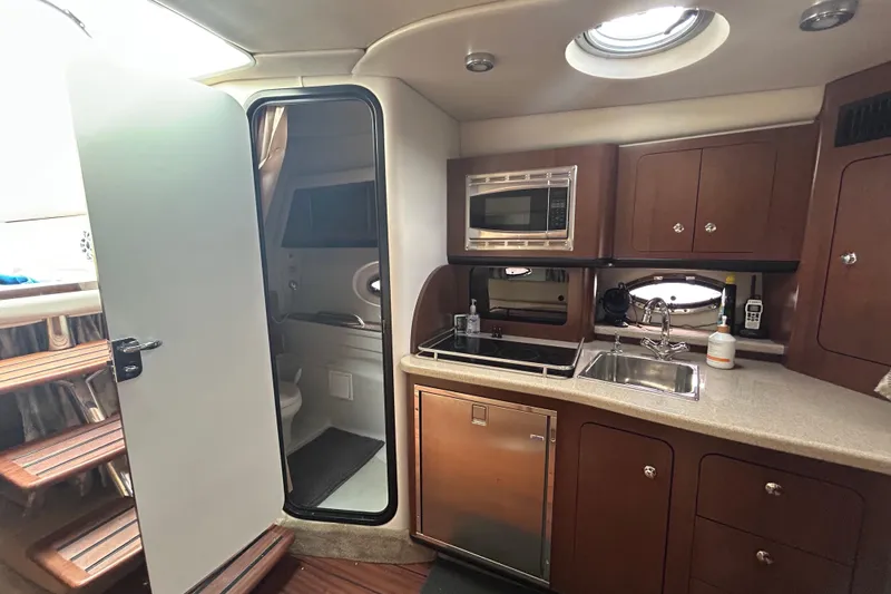 Slide: The Image of Interior of 2015 Crownline 350 SY yacht featuring kitchenette and bathroom access. - 24