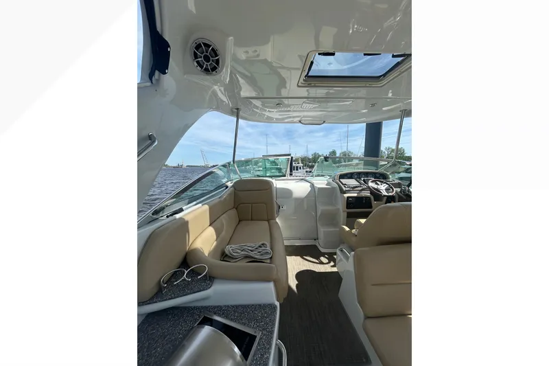 Slide: The Image of Interior view of 2015 Crownline 350 SY boat with beige seating and modern dashboard. - 50