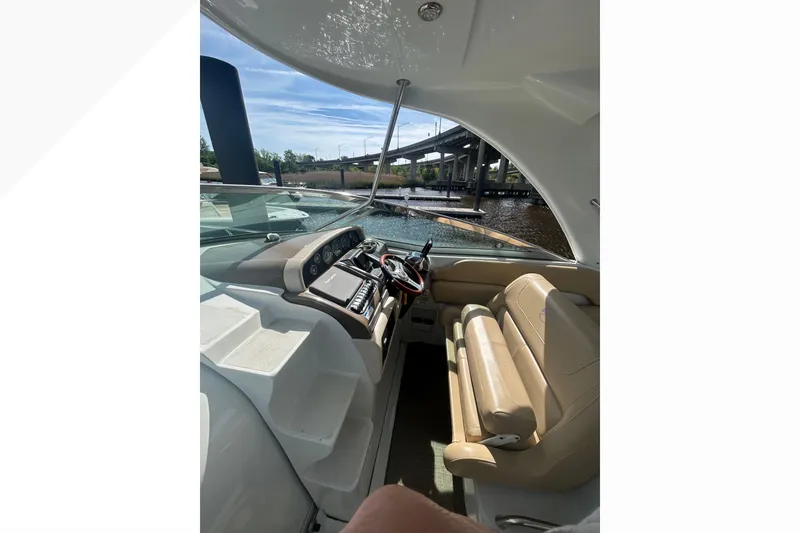 Slide: The Image of Interior view of 2015 Crownline 350 SY yacht cockpit with beige seating and control panel. - 52