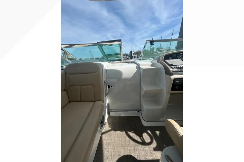 Slide: The Image of Interior view of 2015 Crownline 350 SY boat, featuring seating and dashboard under a clear sky. - 53