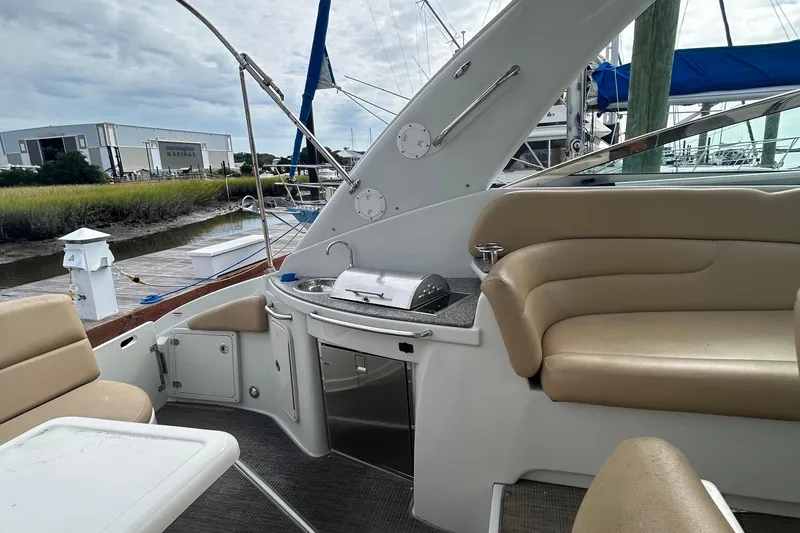 Slide: The Image of 2015 Crownline 350 SY yacht interior with seating and kitchenette, docked near marina. - 7