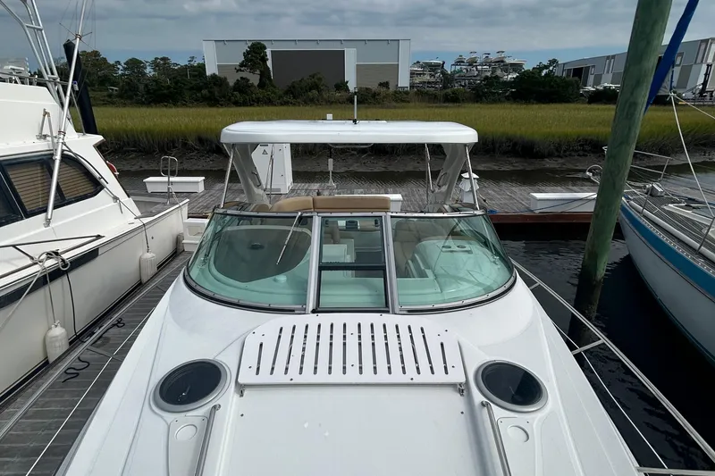 Slide: The Image of 2015 Crownline 350 SY boat docked at marina, featuring sleek design and spacious deck. - 9