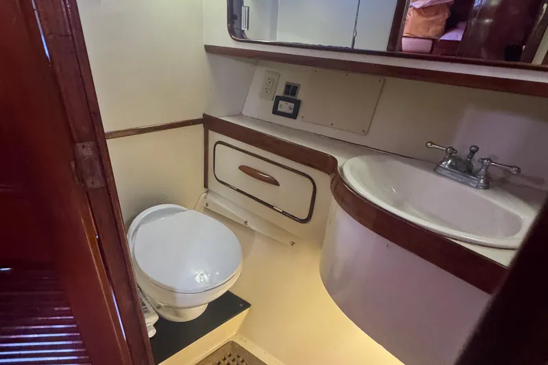 Slide: The Image of 1981 Gulfstar 60 CC yacht bathroom with toilet, sink, and wooden cabinetry. - 16