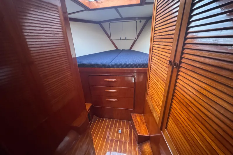 Slide: The Image of 1981 Gulfstar 60 CC cabin interior with wooden finish and cozy bed. - 18