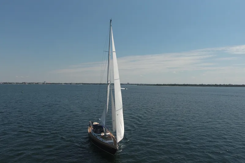 Slide: The Image of 1981 Gulfstar 60 CC sailboat cruising on open water under clear blue skies. - 27