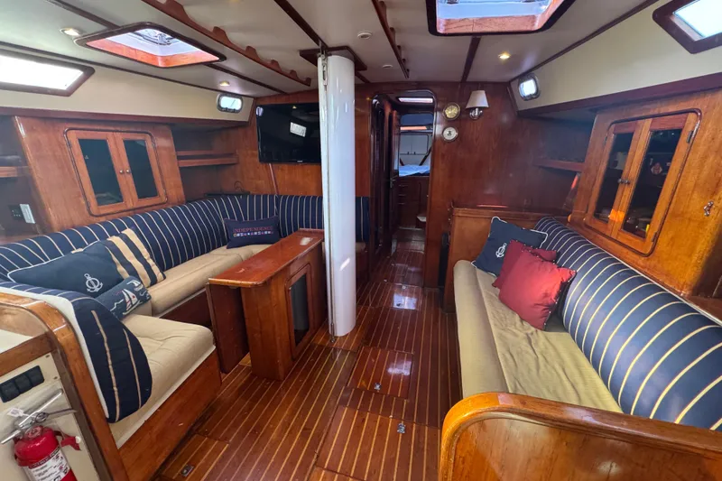 Slide: The Image of Interior of 1981 Gulfstar 60 CC yacht with wood finish and striped seating. - 6