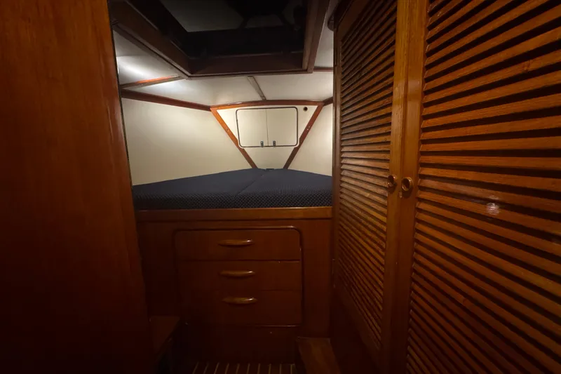 Slide: The Image of 1981 Gulfstar 60 CC yacht interior with wooden cabinetry and cozy sleeping area. - 8