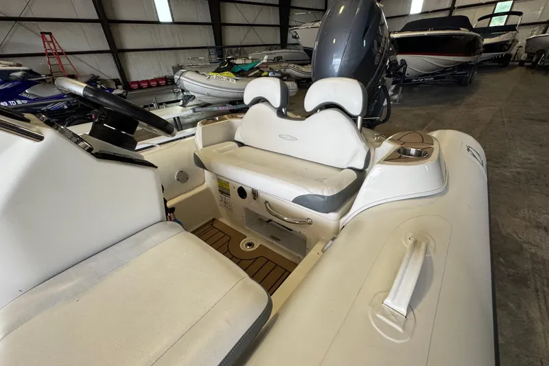 Slide: The Image of 2019 Zodiac Yachtline 400 inflatable boat interior with seating and steering wheel in storage facility. - 9