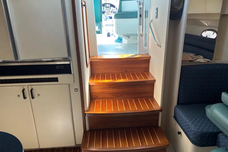 Slide: The Image of Interior of 1991 Trojan 12 Meter Express 400 yacht with wooden stairs and seating area. - 14