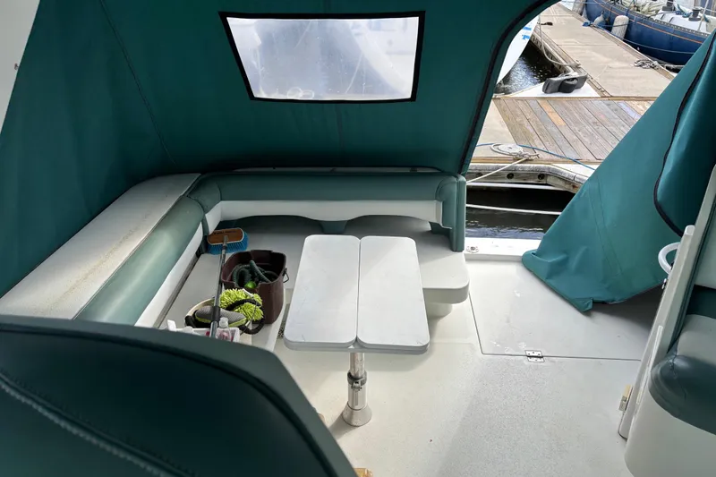 Slide: The Image of 1991 Trojan 12 Meter Express 400 boat interior with seating and table, docked at marina. - 7