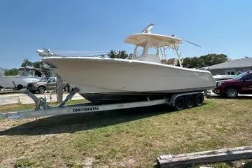 The Image of 2016 Cobia 296 Center Console boat on trailer, parked outdoors. - 1