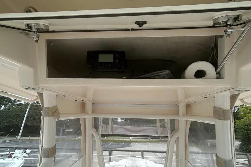 Slide: The Image of 2016 Cobia 296 Center Console storage compartment with radio and paper towel. - 10