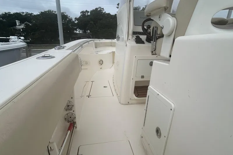 Slide: The Image of 2016 Cobia 296 Center Console boat interior with steering console and seating. - 12