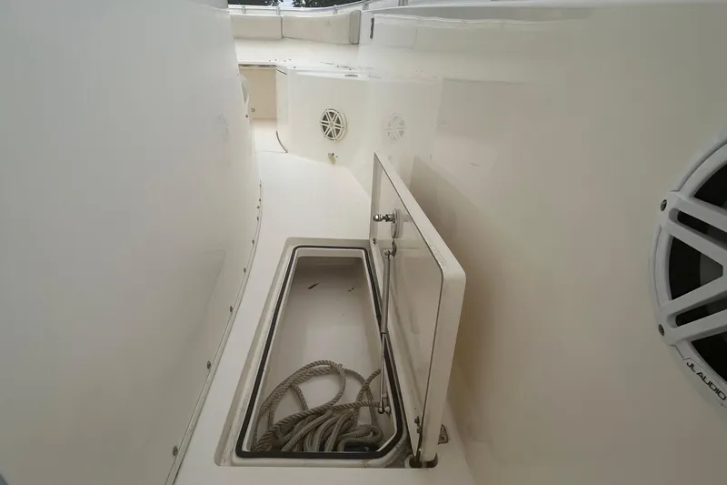 Slide: The Image of 2016 Cobia 296 Center Console boat storage compartment with rope and speaker. - 14