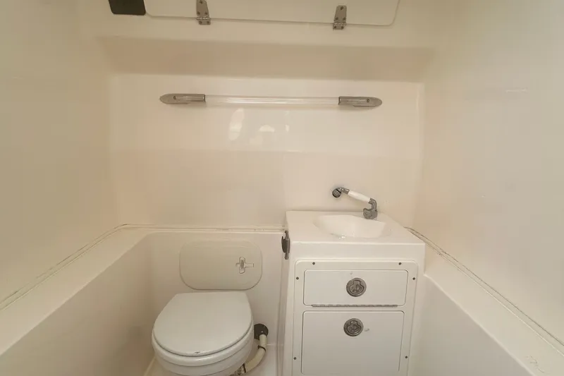 Slide: The Image of 2016 Cobia 296 Center Console boat bathroom with toilet and sink. - 20