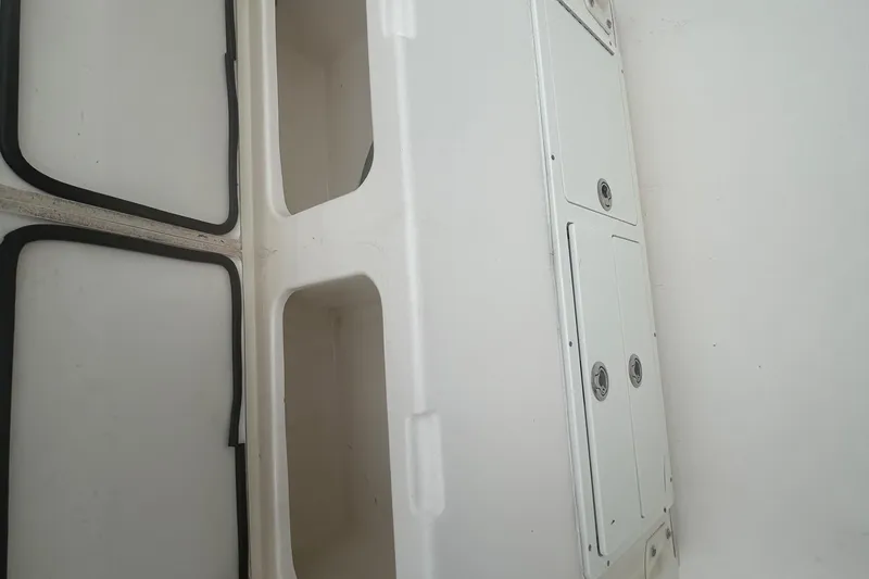 Slide: The Image of 2016 Cobia 296 Center Console storage compartments and hatches, white interior view. - 27