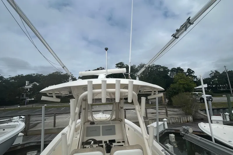 Slide: The Image of 2016 Cobia 296 Center Console boat with fishing rod holders and navigation equipment. - 28