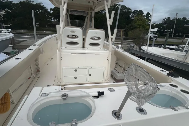 Slide: The Image of 2016 Cobia 296 Center Console boat interior with seating and fishing equipment. - 29
