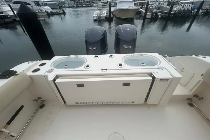 Slide: The Image of 2016 Cobia 296 Center Console boat with twin 300 engines at a marina. - 31