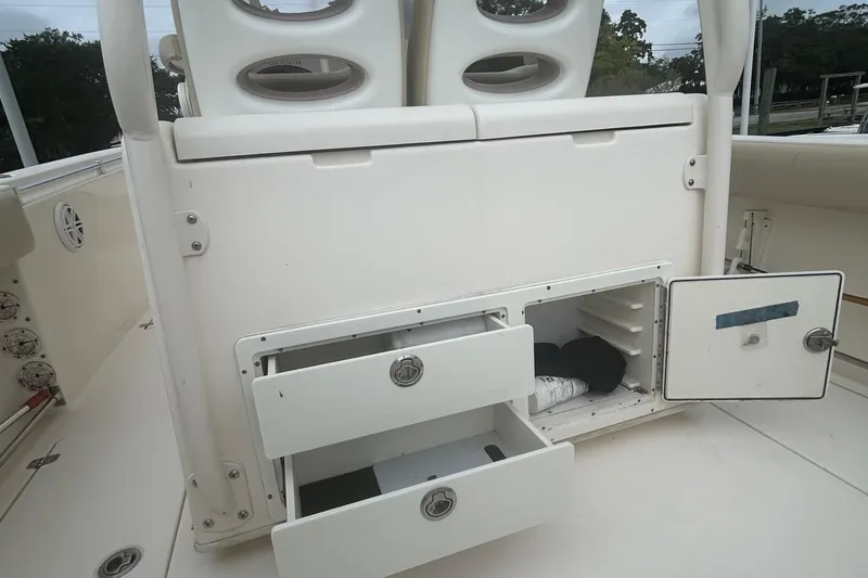Slide: The Image of 2016 Cobia 296 Center Console boat storage compartments with open drawers and hatch. - 32