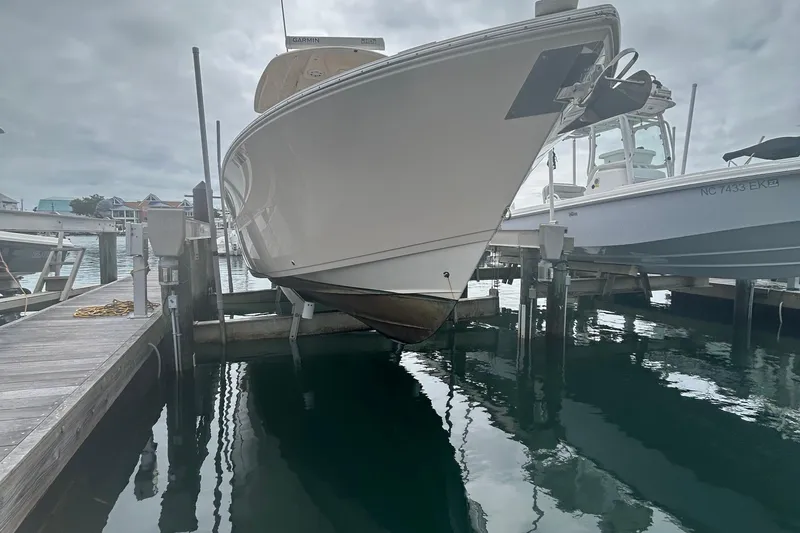 Slide: The Image of 2016 Cobia 296 Center Console boat docked at marina, overcast sky. - 35