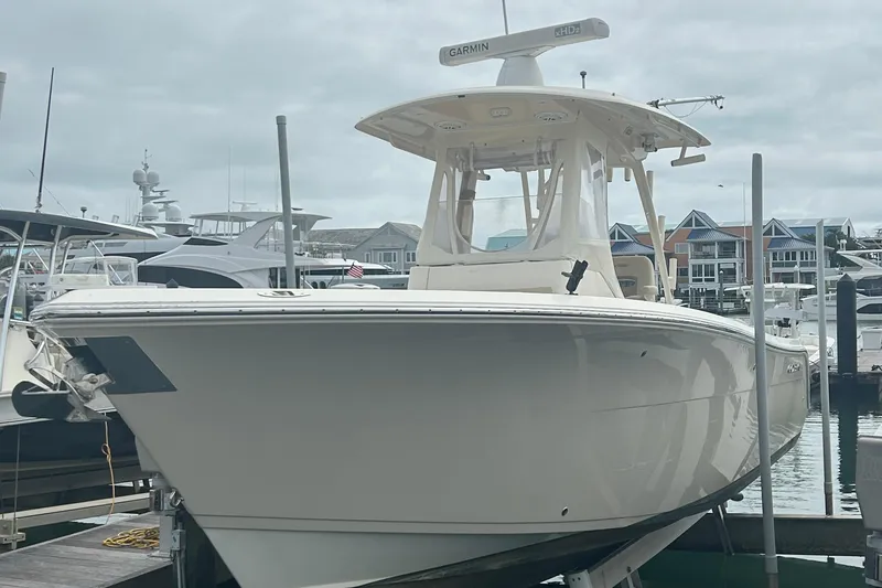 Slide: The Image of 2016 Cobia 296 Center Console boat docked at marina, overcast sky. - 37