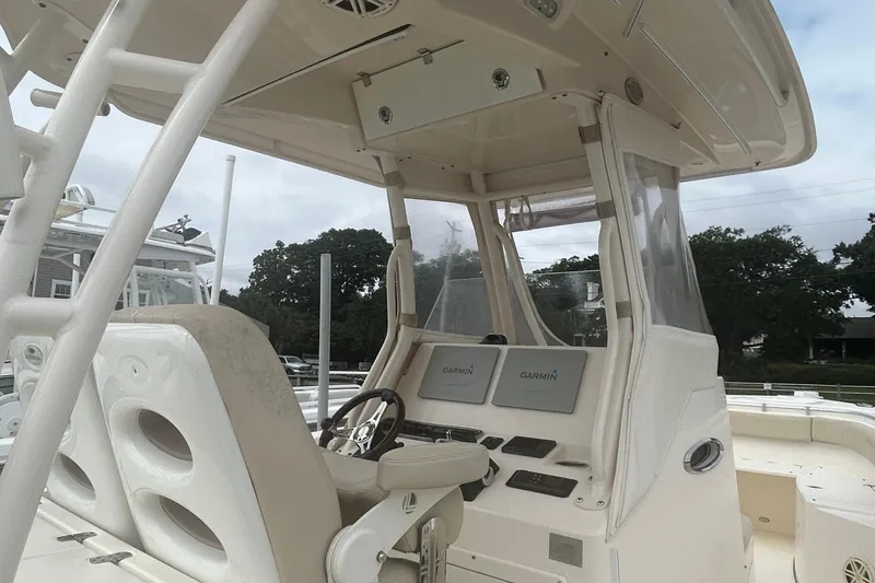 Slide: The Image of 2016 Cobia 296 Center Console boat interior with Garmin displays and steering wheel. - 6