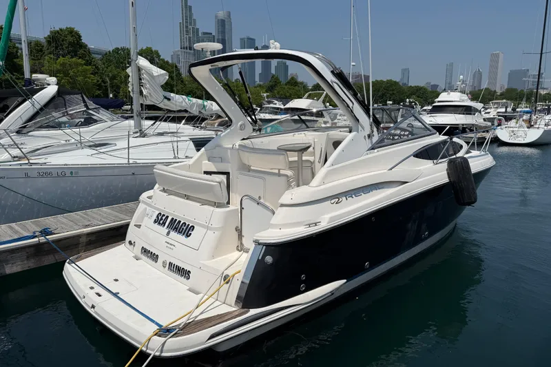The Image of 2007 Regal 3060 Window Express boat docked in a marina with city skyline. - 0