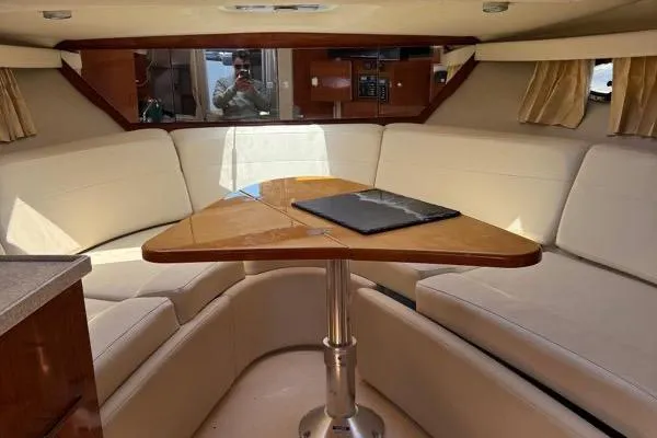Slide: The Image of Interior of 2007 Regal 3060 Window Express with beige seating and wooden table. - 13