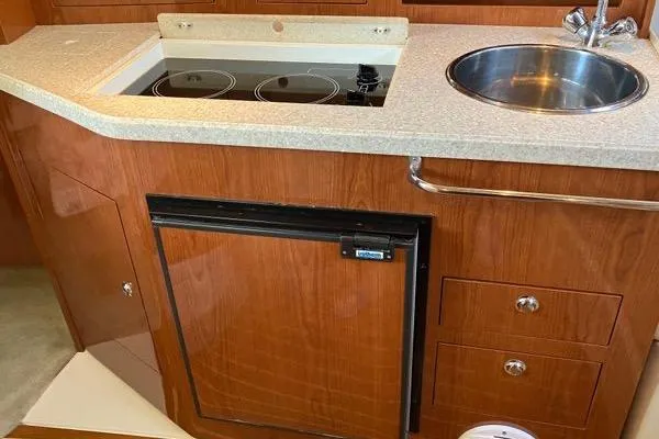 Slide: The Image of 2007 Regal 3060 Window Express yacht kitchen with stove, sink, and fridge. - 16
