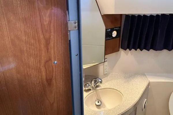 Slide: The Image of 2007 Regal 3060 Window Express boat bathroom with sink, mirror, and wooden door. - 20