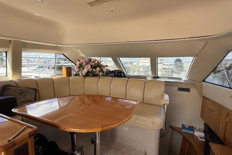 Slide: The Image of Interior of 2006 Carver 38 Super Sport yacht with leather seating and wooden table. - 11