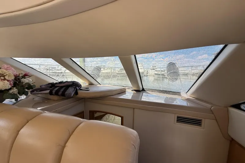 Slide: The Image of Interior of 2006 Carver 38 Super Sport yacht with leather seating and marina view. - 12