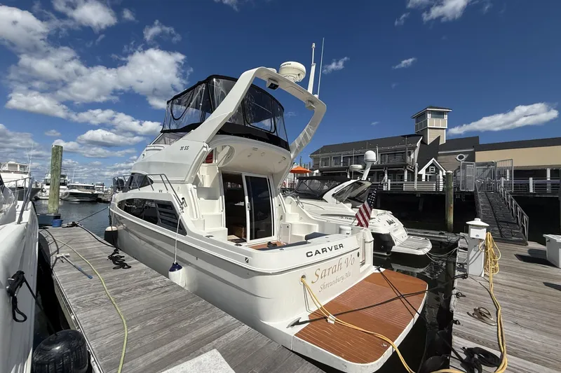 Slide: The Image of 2006 Carver 38 Super Sport yacht docked at marina under blue sky. - 2