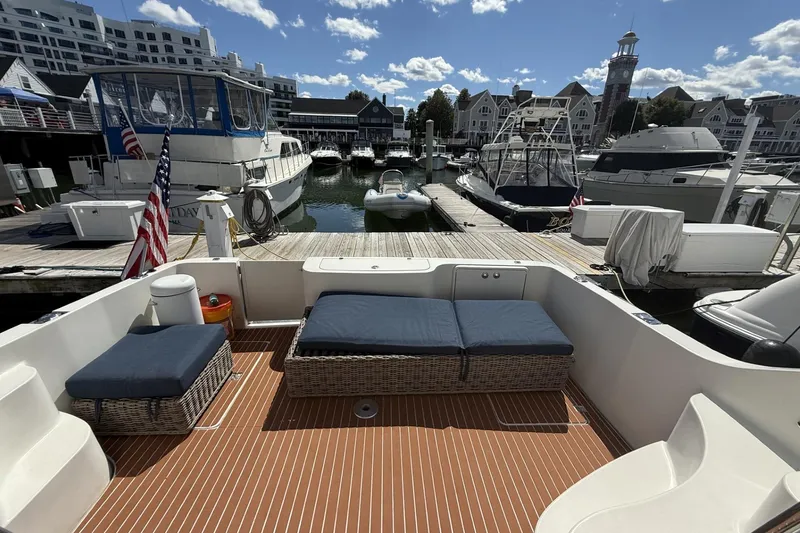 Slide: The Image of 2006 Carver 38 Super Sport yacht docked at marina with seating area and American flag. - 4