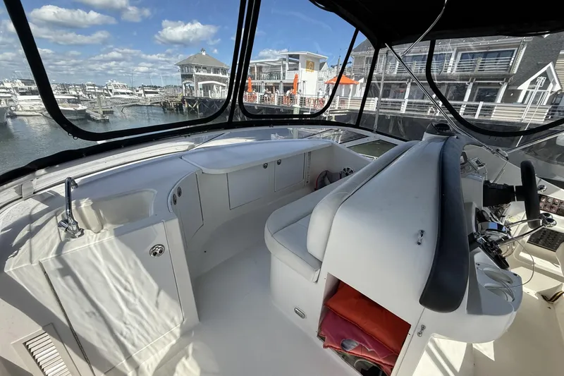 Slide: The Image of 2006 Carver 38 Super Sport yacht interior with marina view, featuring helm and seating area. - 8