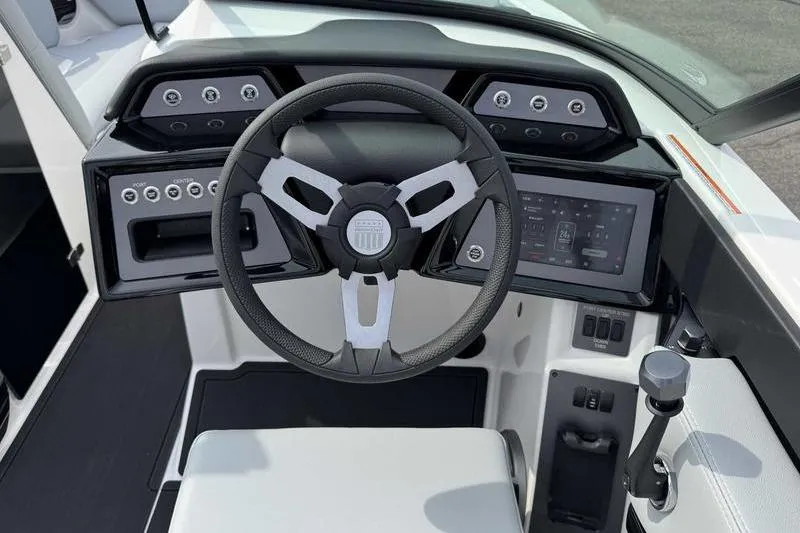 Slide: The Image of 2026 MasterCraft NXT22 boat dashboard with steering wheel and digital display. - 11