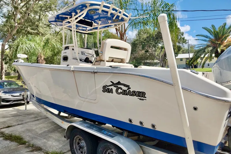 Slide: The Image of 2019 Carolina Skiff Sea Chaser 27 HFC boat on trailer, surrounded by trees. - 21