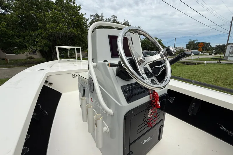 Slide: The Image of 2021 Maverick 17 HPX-S boat console with steering wheel and controls, outdoors. - 20