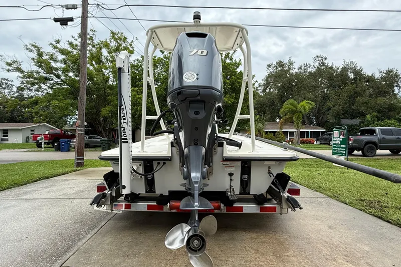 Slide: The Image of 2021 Maverick 17 HPX-S boat with outboard motor on trailer, parked in residential area. - 3