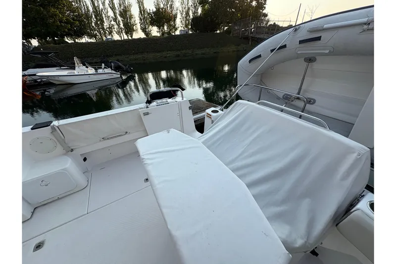 Slide: The Image of 2018 Cutwater C-30 CB boat interior with white seating, docked by a calm waterway. - 12