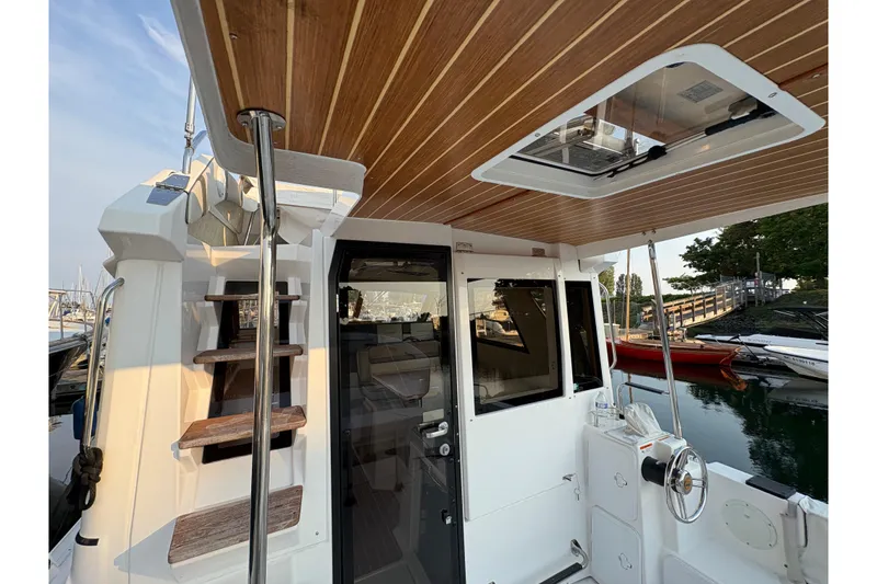 Slide: The Image of 2018 Cutwater C-30 CB boat interior with wooden ceiling and staircase, docked by the water. - 16