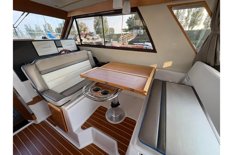 Slide: The Image of 2018 Cutwater C-30 CB boat interior with seating, table, and Garmin navigation displays. - 19