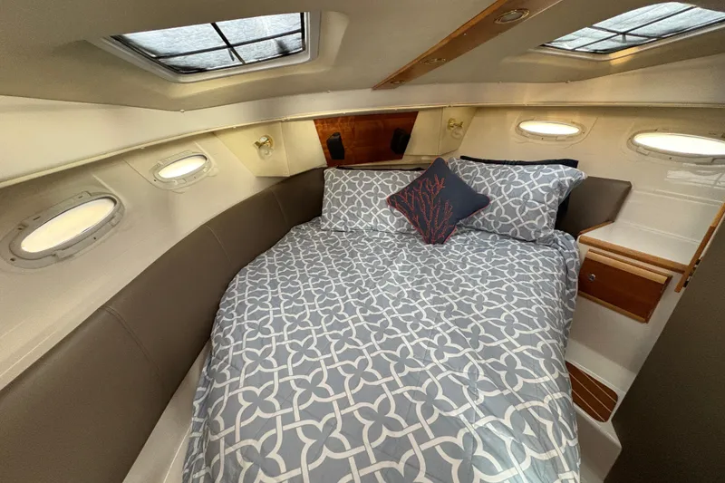 Slide: The Image of 2018 Cutwater C-30 CB cabin interior with cozy bed and decorative pillows. - 32