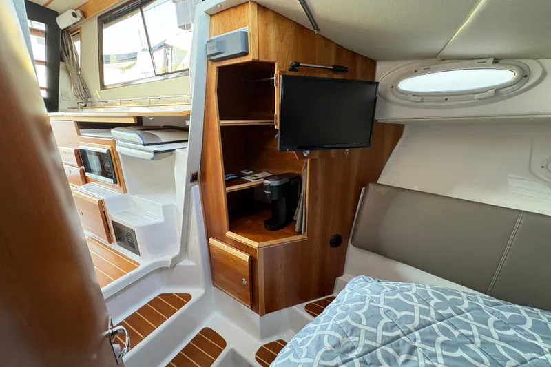 Slide: The Image of 2018 Cutwater C-30 CB interior with wood accents, TV, and cozy seating area. - 33