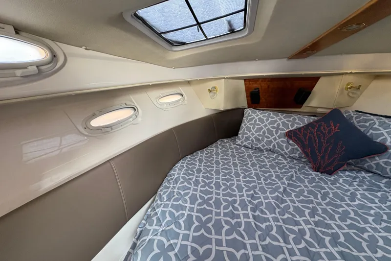Slide: The Image of 2018 Cutwater C-30 CB cabin interior with patterned bedding and porthole windows. - 34