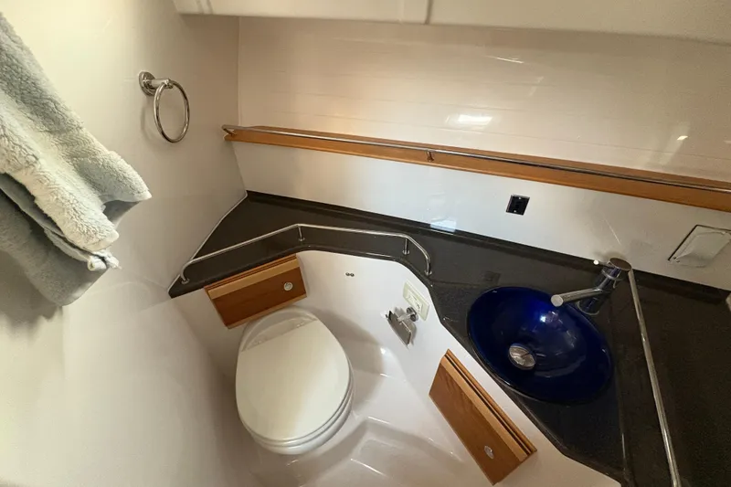 Slide: The Image of 2018 Cutwater C-30 CB boat bathroom with toilet, blue sink, and towel ring. - 37