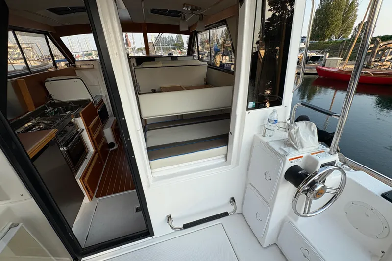 Slide: The Image of 2018 Cutwater C-30 CB boat interior with kitchen and seating area, docked by the water. - 44