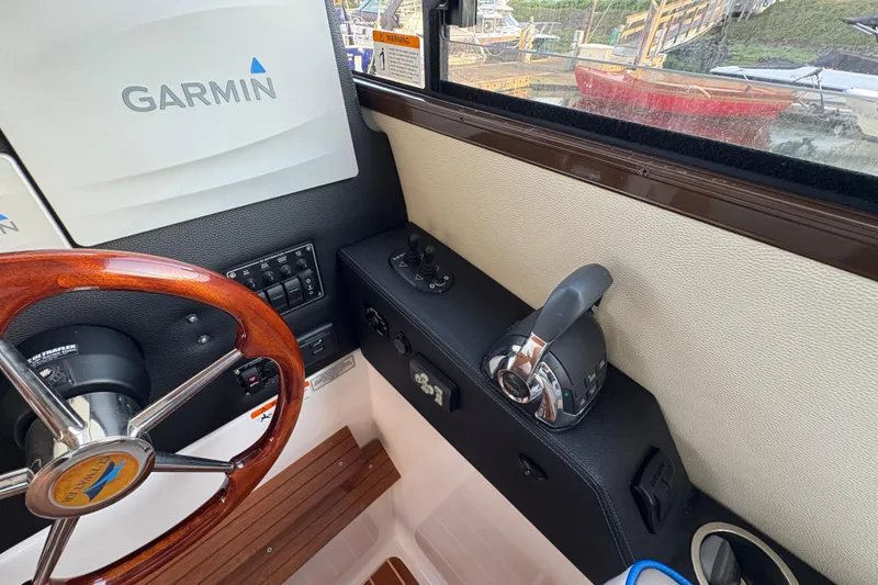 Slide: The Image of 2018 Cutwater C-30 CB helm with Garmin navigation, wooden steering wheel, and control panel. - 48